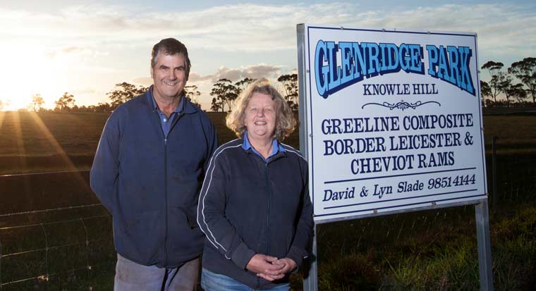 couple standing in front of their glendridge farm sign